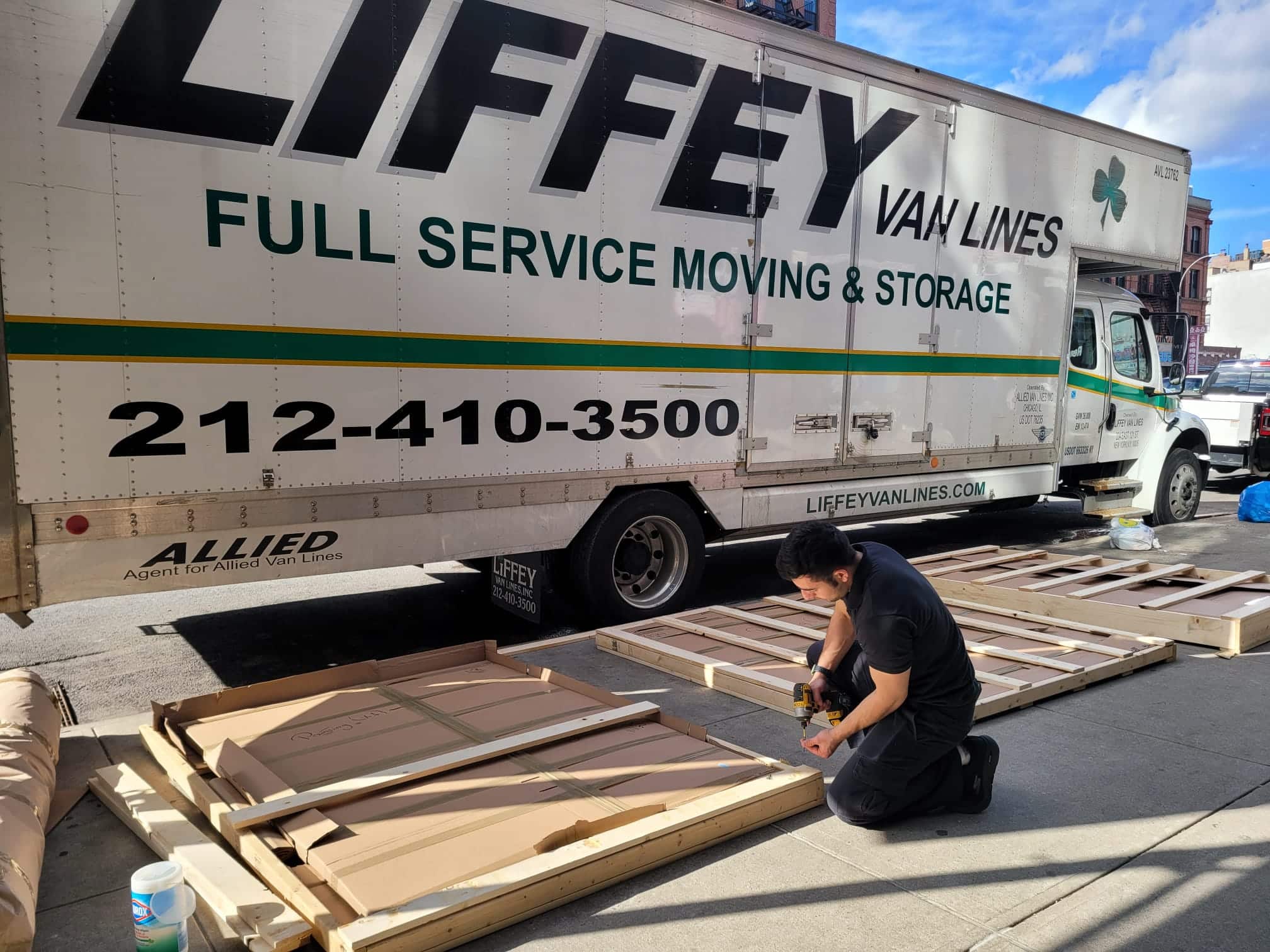 Professional movers in action navigating NYC apartment building with wrapped furniture during residential move
